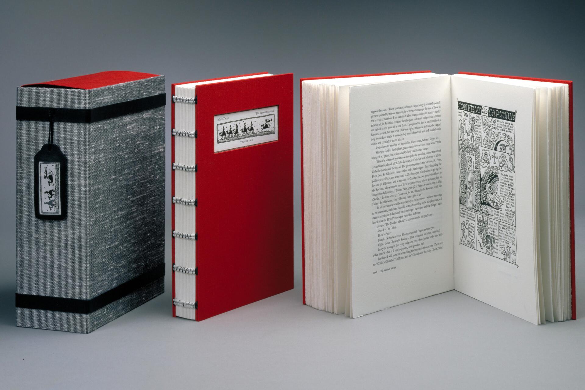 A full set of The Innocents Abroad, showing the case with tag, second volume with spine, first volume open to a spread of text, left, and a cartoon illustration, right